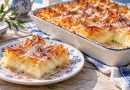 Goldbraune Bougatsa mit knusprigen Filoteigfalten, Puderzucker und Zimt in einer Form und als Stück auf einem blau-weißen Teller.