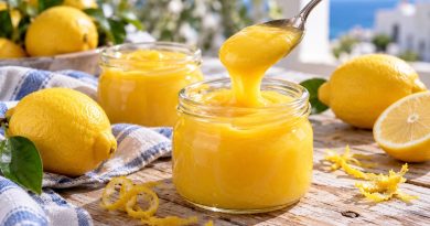 Lemon Curd mit ganzer Zitrone in zwei Gläsern mit Zitronen und einem Löffel Zitronencreme.