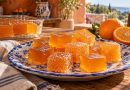 Illustration weicher Orangen-Geleewürfel, teils frisch in Zucker gewälzt, in einer rustikalen griechischen Küche.