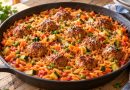 Orzo-Pfanne mit Hackbällchen, Möhren, Zucchini und Erbsen in Tomatensoße, mit Petersilie bestreut.