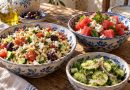 Orzo-Salat, Wassermelonen-Feta-Salat und Gurkensalat in blau-weißen Keramikschüsseln